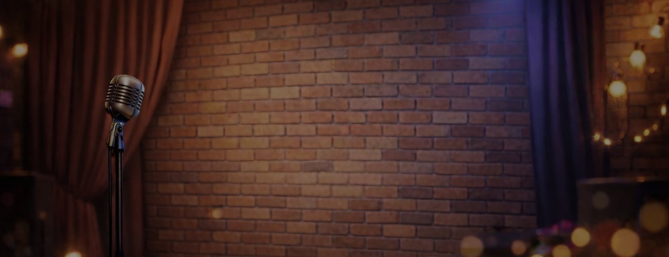empty comedy club stage microphone and brick wall